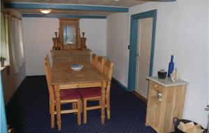 a dining room with a wooden table with chairs and a mirror at Three-Bedroom Holiday Home In Blavand in Blåvand