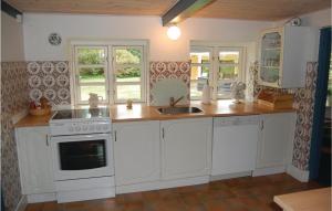 a kitchen with white cabinets and a sink at Three-Bedroom Holiday Home In Blavand in Blåvand