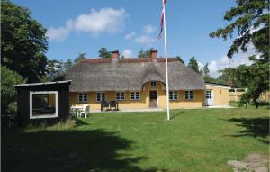 a large yellow house with a flag in the yard at Three-Bedroom Holiday Home In Blavand in Blåvand +22 photos