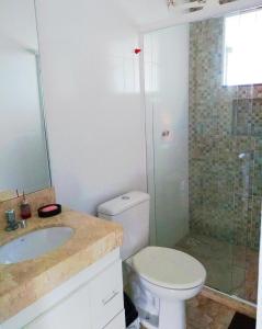 uma casa de banho com um WC, um lavatório e um chuveiro em CASA ACONCHEGANTE em São Lourenço