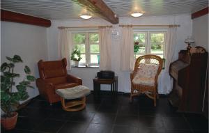 a living room with two chairs and a couch and windows at Three-Bedroom Holiday Home In Blavand in Blåvand
