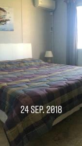 una camera da letto con un letto con una coperta sopra di Noctilucas en PuntaNegra, cerquita de la playa y piscina climatizada a Punta Colorada