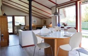 comedor con sillas blancas y mesa en Nice Home In Dronningmlle With 3 Bedrooms And Wifi, en Dronningmølle