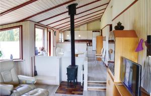 una sala de estar con estufa de leña en una casa en Nice Home In Dronningmlle With 3 Bedrooms And Wifi, en Dronningmølle