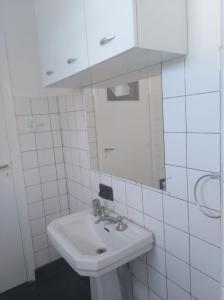 W białej łazience znajduje się umywalka i lustro. w obiekcie Departamento céntrico Tupungato w mieście Tupungato