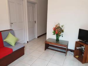 a living room with a couch and a vase of flowers on a table at MJM Villa in Colombo +10 photos