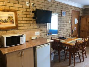 a kitchen with a counter with a microwave and a table at Lake Front Motel in The Entrance