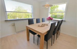 een eetkamer met een houten tafel en zwarte stoelen bij Stunning Home In Augustenborg With Kitchen in Augustenborg