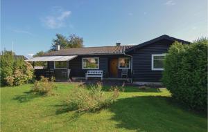 a black house with a bench in a yard at Stunning Home In Augustenborg With Kitchen in Augustenborg