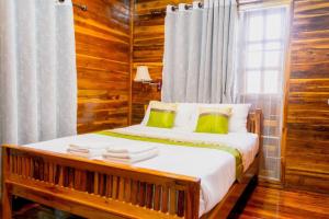 a bedroom with a bed with wooden walls and a window at Imsuk Homestay at Chiang Rai in Chiang Rai