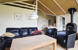 sala de estar con sofá de cuero negro y mesa en Awesome Home In Haderslev With 4 Bedrooms And Sauna en Kelstrup Strand