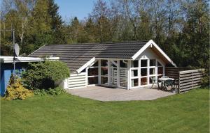 a small cabin with a deck in a yard at Stunning Home In Oksbl With Kitchen in Oksbøl