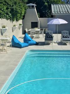 a swimming pool with blue pillows next to a patio at Villa Eike in Grabouw