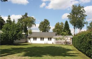 a white house with a fence and a yard at Awesome Home In Silkeborg With 2 Bedrooms And Wifi in Silkeborg