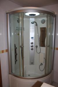 um chuveiro numa casa de banho com uma porta de vidro em Gite Appartement "Le bel étage" jacuzzi piscine 6 Personnes em Godinne