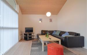 FjellerupにあるNice Home In Glesborg With 3 Bedrooms, Sauna And Wifiのリビングルーム(ソファ、テーブル付)