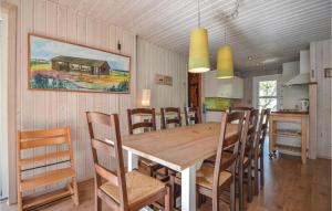 a kitchen and dining room with a wooden table and chairs at Amazing Home In Rm With Wifi in Bolilmark