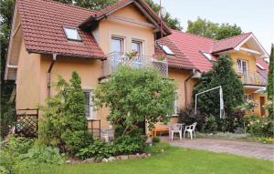a house with a table and chairs in the yard at Holiday Home Rewal Olszynowa in Rewal