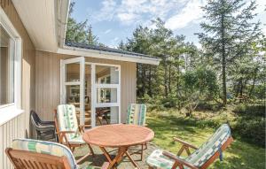 a patio with a table and chairs on a house at Amazing Home In Rm With Wifi in Bolilmark
