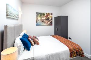 um quarto com uma cama e um quadro na parede em St Albans City Apartments - Near Luton Airport and Harry Potter World em Saint Albans