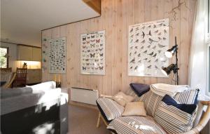 a living room with a couch and a wall with posters at Holiday Home Egelunden Hadsund Vi in Helberskov +11 photos