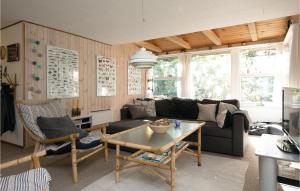 a living room with a couch and a table at Holiday Home Egelunden Hadsund Vi in Helberskov