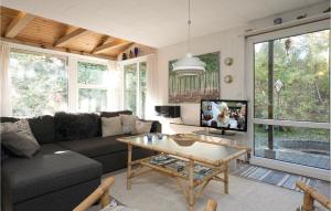 a living room with a couch and a table at Holiday Home Egelunden Hadsund Vi in Helberskov