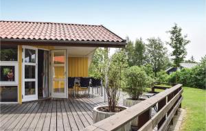SønderbyにあるAwesome Home In Juelsminde With 4 Bedrooms, Sauna And Wifiのウッドデッキ(ポーチ付)付きの家
