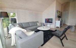 een woonkamer met een bank en een tafel bij Amazing Home In Rdby With Sauna, Wifi And Outdoor Swimming Pool in Kramnitse