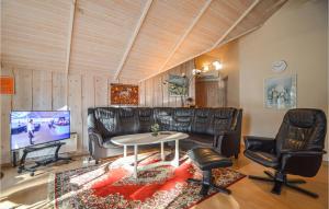 ロモ・キルケビーにあるStunning Home In Rm With Saunaのリビングルーム(革張りのソファ、椅子、テレビ付)