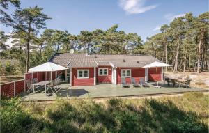 een rode hut met een terras en een tafel en stoelen bij Beautiful Home In Nex With Kitchen in Vester Sømarken