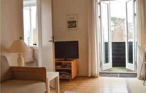 a living room with a flat screen tv and a living room at Awesome Apartment In Hornbk With House Sea View in Hornbæk