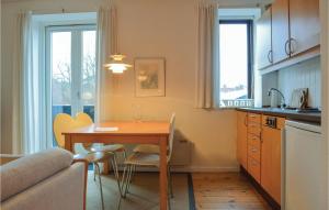 a kitchen with a table and chairs in a room at Awesome Apartment In Hornbk With House Sea View in Hornbæk