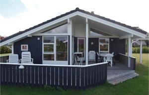 a screened in porch with a deck with chairs at Holiday Home Elsdyrstien Væggerløse Vi in Marielyst