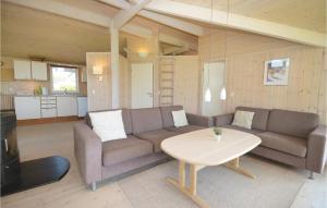 a living room with a couch and a table at Holiday Home Elsdyrstien Væggerløse Vi in Marielyst