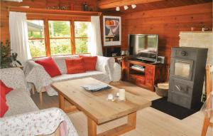 a living room with a couch and a wood stove at 2 Bedroom Cozy Home In Otterup in Otterup