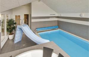 a indoor swimming pool with a slide in a building at Amazing Home In Tranekr With Sauna in Hou