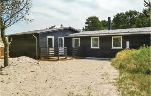 a log cabin with a sandy yard in front of it at Nice Home In Fan With 3 Bedrooms And Internet in Fanø