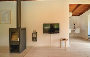a living room with a fireplace and a tv on a wall at Nice Home In Fan With 3 Bedrooms And Internet in Fanø