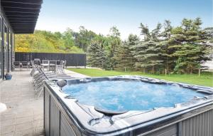 a large hot tub on a patio with chairs at Nice Home In Ebeltoft With Wifi in Ebeltoft