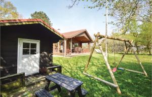 a log cabin with a swing and a house at 3 Bedroom Amazing Home In Haderslev in Haderslev