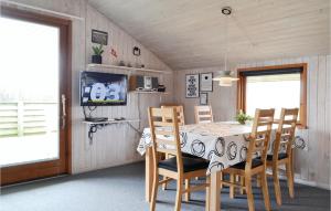 BjerregårdにあるStunning Home In Hvide Sande With House A Panoramic Viewのダイニングルーム(テーブル、椅子、テレビ付)
