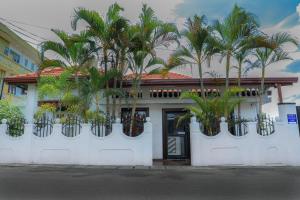 ein weißes Gebäude mit Palmen in Pflanzen darauf in der Unterkunft Bon Voyaage Tourist Inn in Trincomalee
