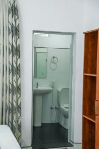ein Badezimmer mit Waschbecken, Toilette und Spiegel in der Unterkunft Bon Voyaage Tourist Inn in Trincomalee + 37 Fotos