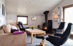 BjerregårdにあるStunning Home In Hvide Sande With House A Panoramic Viewのリビングルーム(ソファ、椅子、薪ストーブ付)