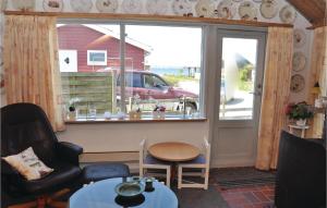 a living room with a window and a chair and a table at Three-Bedroom Holiday Home In Broager in Broager