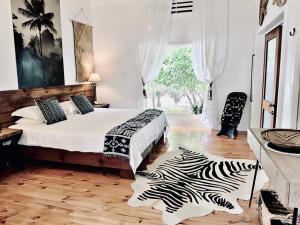 a bedroom with a bed and a zebra rug at Sails Beach House in Luganville