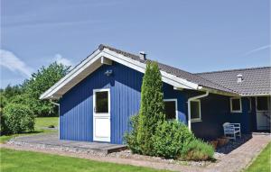 a blue shed with a white door in a yard at Holiday Home Bredekjærs-Åsen Græsted V in Udsholt Sand