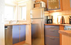 a kitchen with a stainless steel refrigerator and cabinets at Holiday Home Bredekjærs-Åsen Græsted V in Udsholt Sand