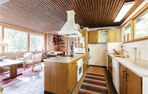 uma cozinha com armários de madeira e uma sala de jantar com uma mesa em 2 Bedroom Pet Friendly Home In Nex em Bedegård